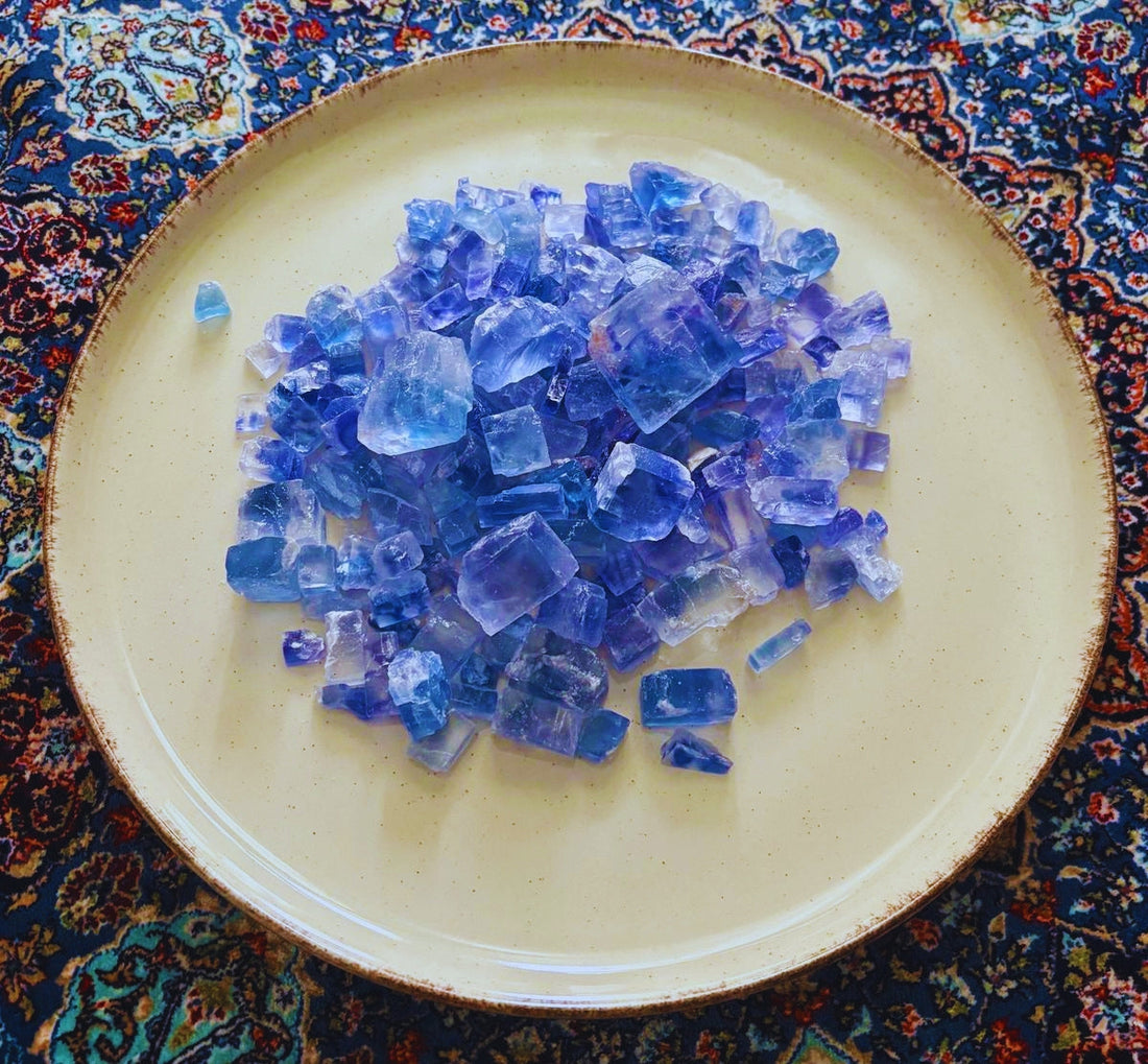 place with a hanfdul of perian blue salt.  Plate is on a persian rug 